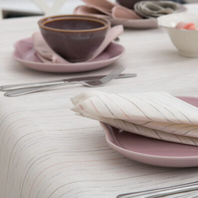 Milchweiße Halbleinentischdecke mit bunten Streifen.