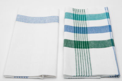 Zwei Küchentücher: weiß mit blauen Streifen und weiß mit grünen und blauen Streifen.