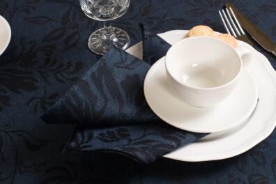 Dunkelblaue Halbleinen-Serviette mit schwarzen Blumen.