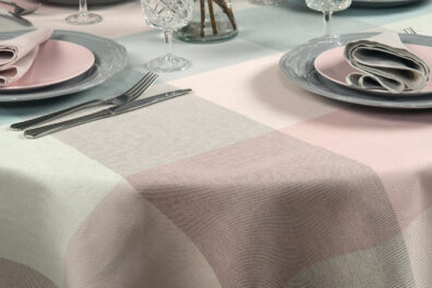 Runde (ovale) Halbleinentischdecke mit großen Karos in Rosa, Grünlich und Hellgrau.
