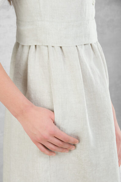 Hellgraues Leinenkleid mit gerafftem Rock und Taschen.