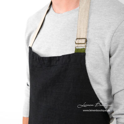 Schwarze Leinen-Küchenschürze mit naturgrauem Halsband und grünem Detail