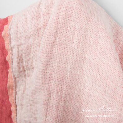 Andere Seite des Leinenstoffes ist weiß-creme meliert, mit rosa Punkten.