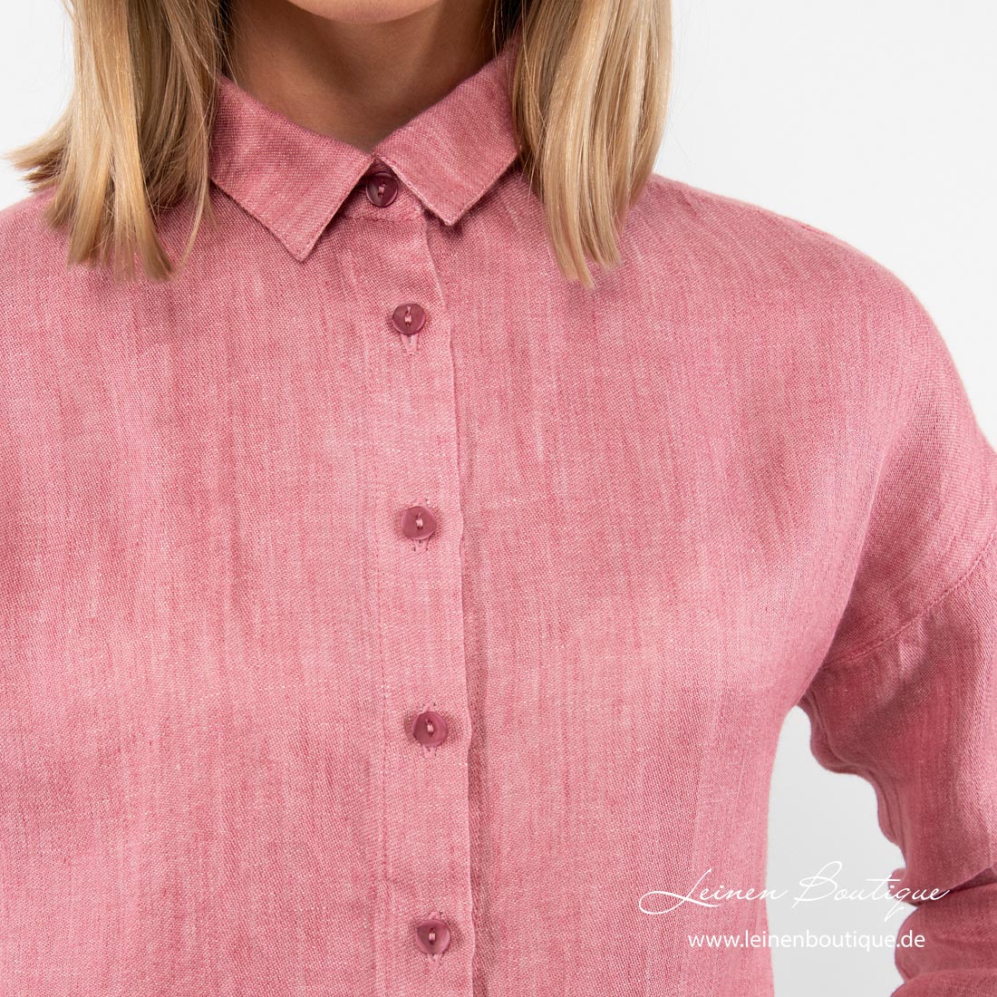 Rosa Leinenbluse hat lange Knopfleiste mit dunkleren Knöpfen