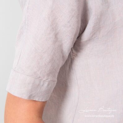 Der Leinenstoff der Bluse ist aus hellgrauen und blassrosa Garnen gewebt