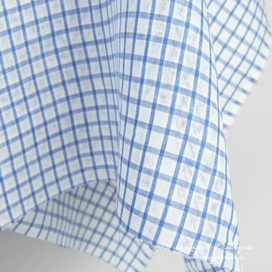 Leinenstoff mit dichten blauen Streifen und durchsichtigen weißen Karos
