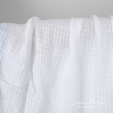 Schneeweißer Leinenstoff mit durchsichtigen und dicht gewebten Karos vorgewaschen