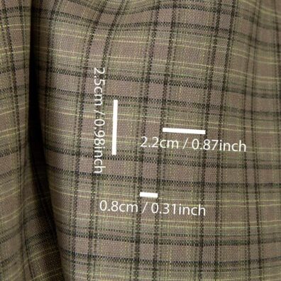 Leinenstoff mit dunkelgrünen und dunkelgrauen Karos auf dem beigen Grund